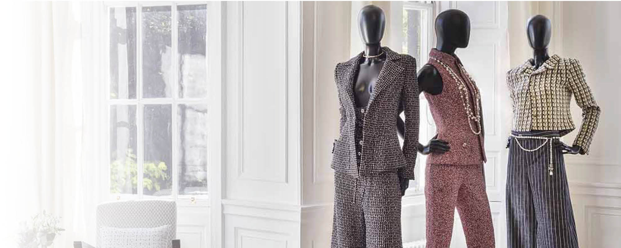 The interior of a Scottish townhouse with 3 mannequins wearing clothings from a luxury tweed collection